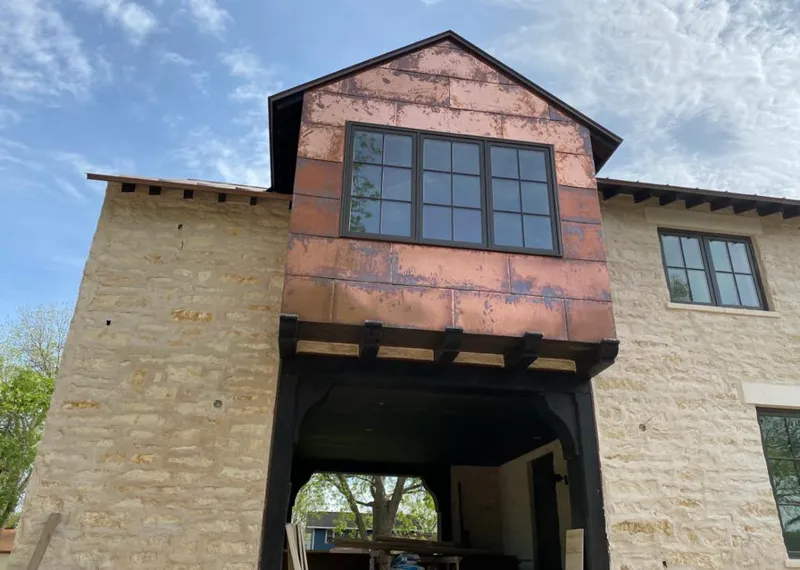 Copper metal panel facade on a stone building for Roof Repair in Twin Lakes